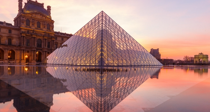 Riflesso sull'acqua della Piramide del Louvre al tramonto. Parigi